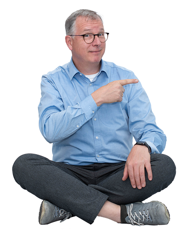 Uwe Fenner von fenner Communication sitzt im Schneidersitz und zeigt auf fünf Gründe für Webdesign mit WordPress.