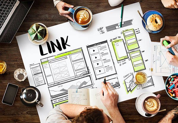 Marketingteam bespricht anhand einer Skizze eine Linkstrategie Ihrer Websebseite.